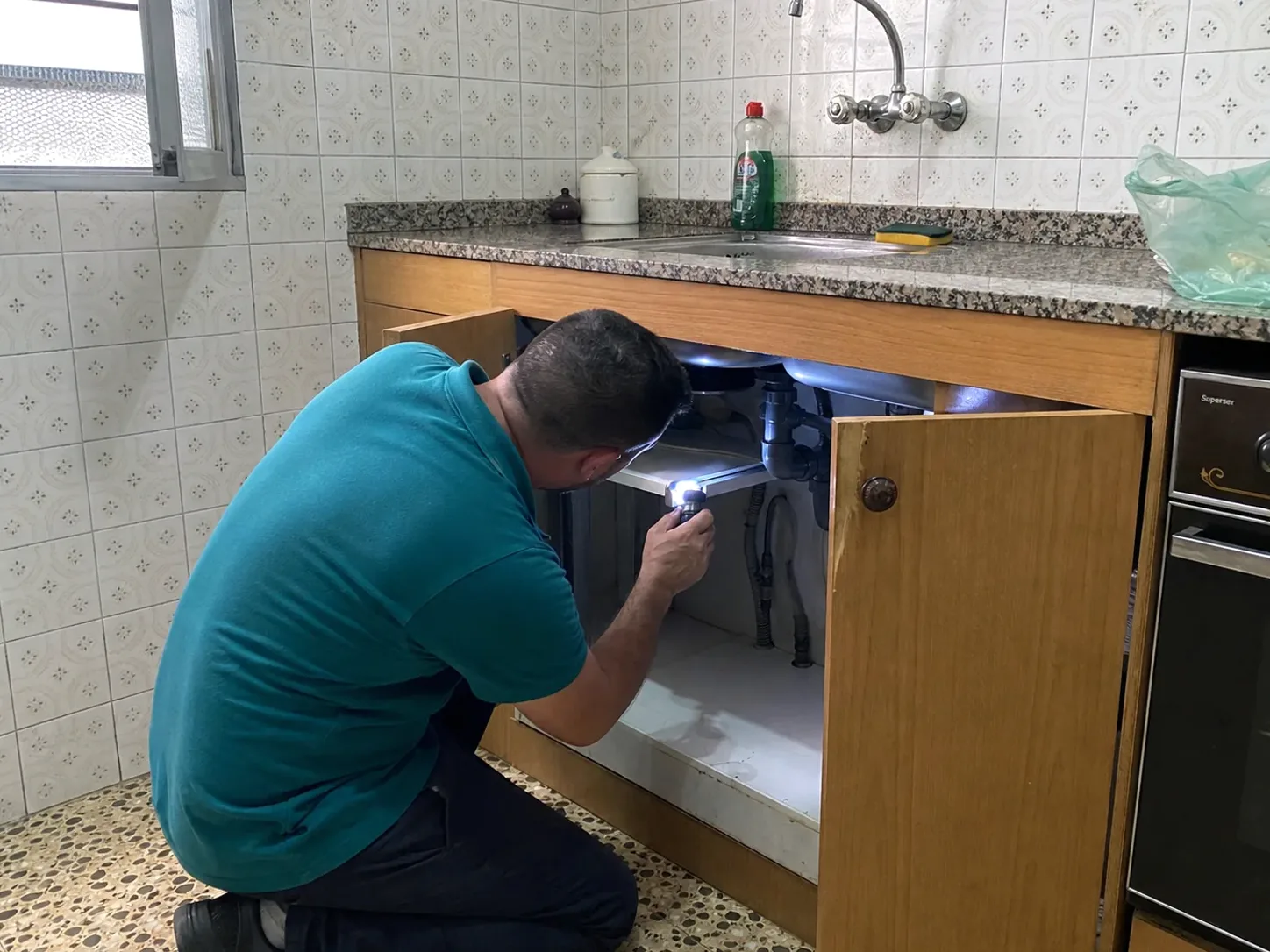 Técnico de LlagostaPlagas inspeccionando una cocina con linterna